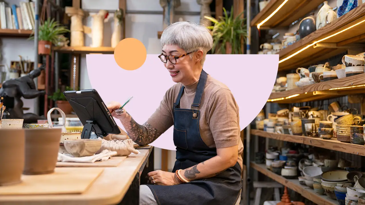 A small-business owner working at a tablet in her pottery studio