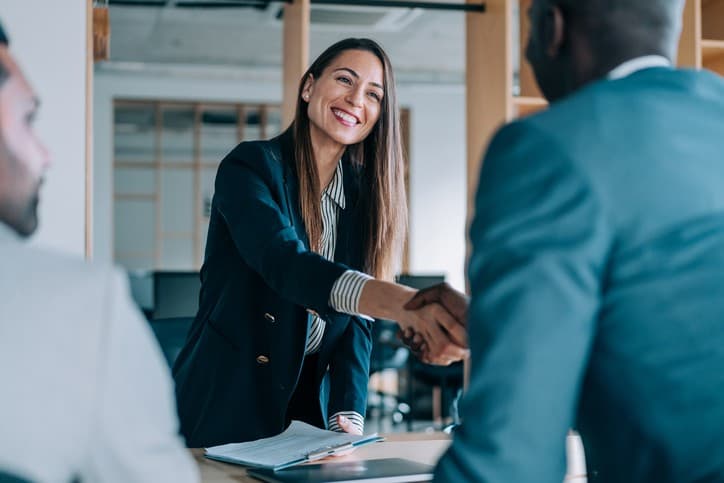 A graduate shaking hands with an employer at an interview